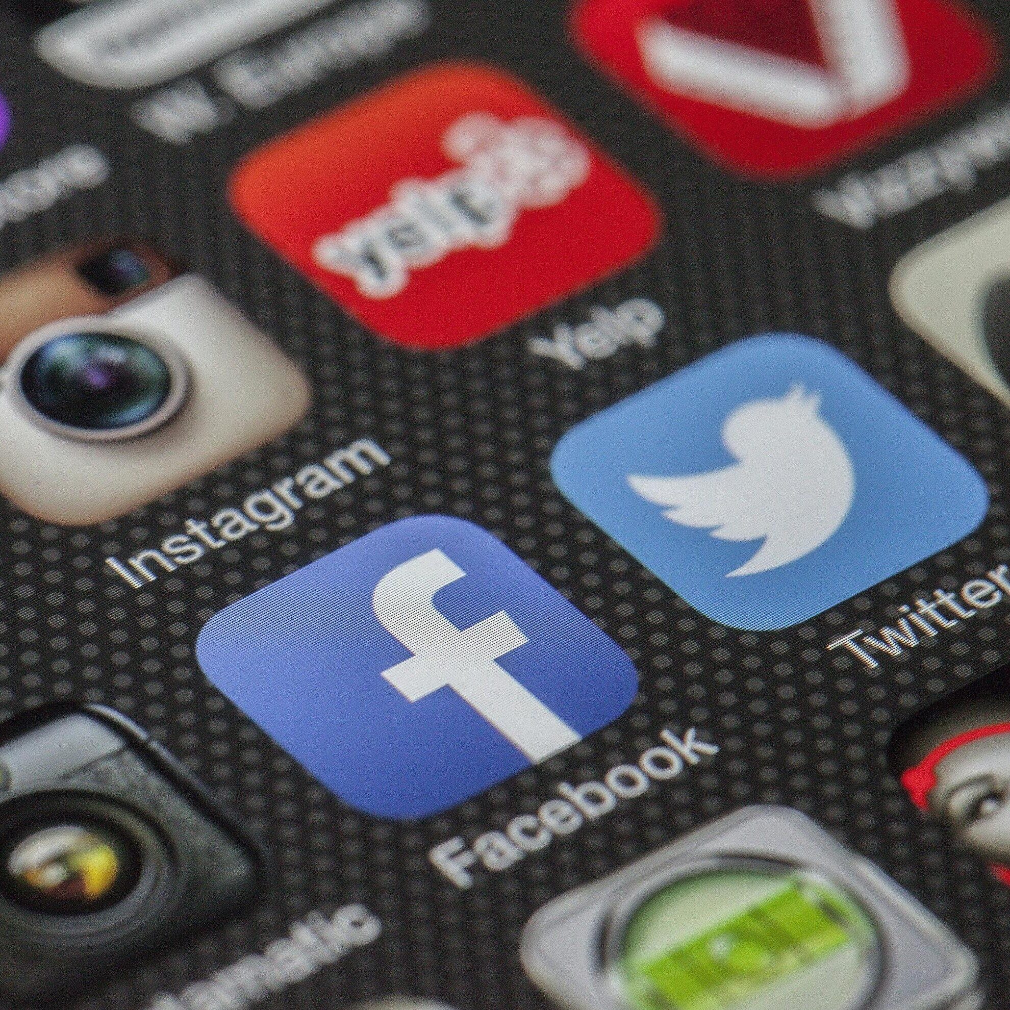 Close-up image of various social media app icons on a smartphone screen.